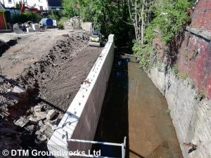 Concrete block river retaining wall - DTM Groundworks Ltd